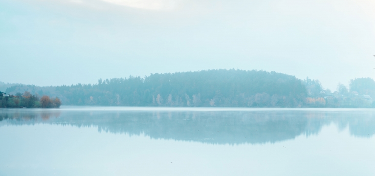 A panoramic shot of Lake Austin on a calm, misty morning
