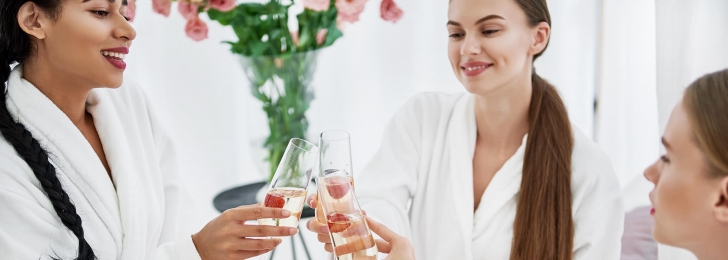 A group of women raise their glasses for a toast while relaxing in their robes at the Lake Austin Resort Spa.