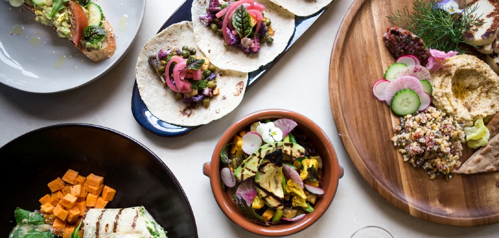 An overhead shot of several dishes of colorful Mediterranean style foods.