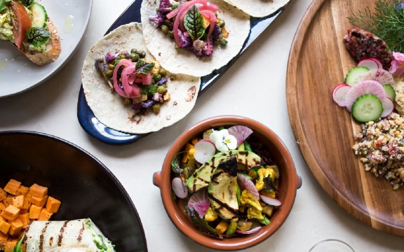 An overhead shot of several dishes of colorful Mediterranean style foods.