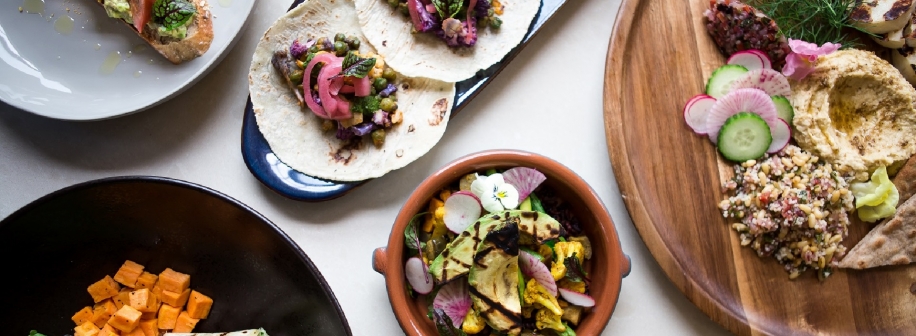 An overhead shot of several dishes of colorful Mediterranean style foods.