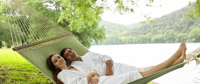 Couple in robes in a hammock after spa visit