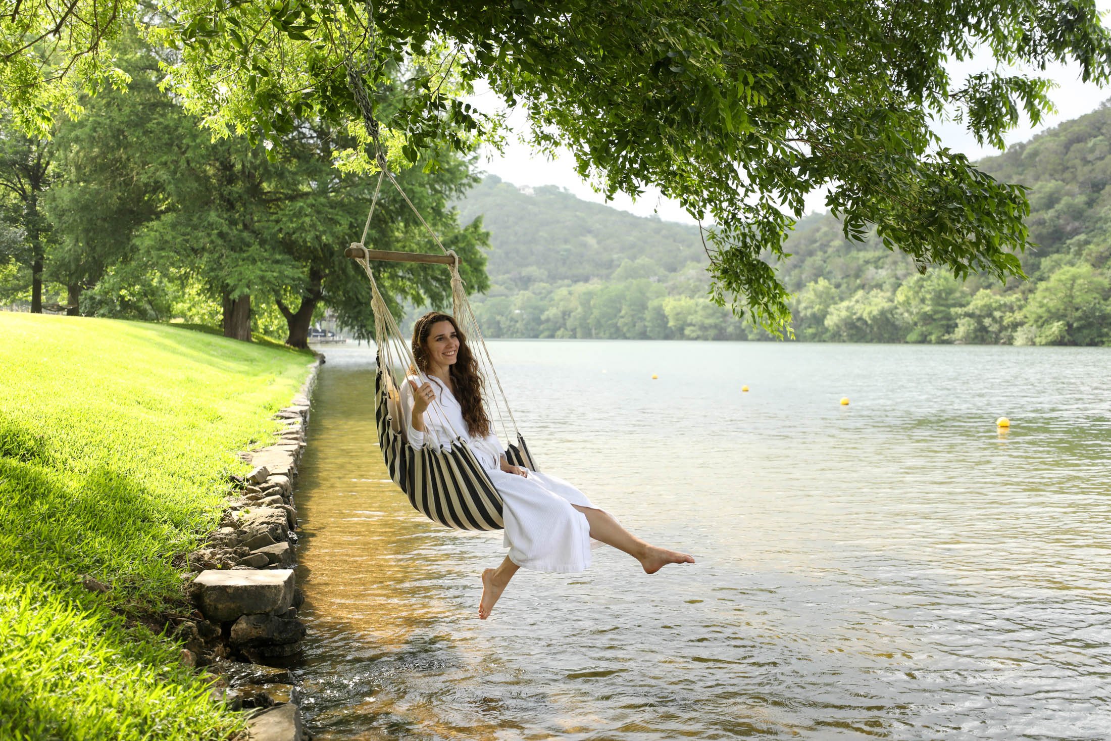 A woman swinging by the lake