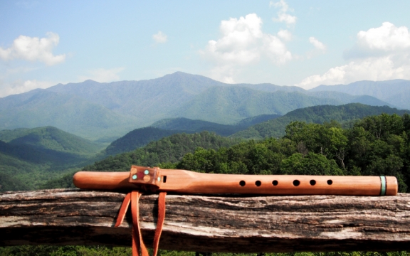 A wooden flute overlooking the lush green mountains and valleys surrounding Lake Austin