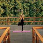 Woman doing yoga on yoga dock