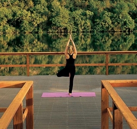 Woman doing yoga on yoga dock