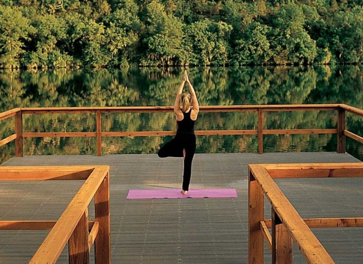 Woman doing yoga on yoga dock