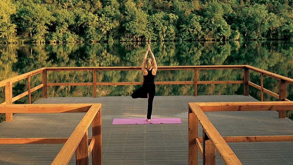 Woman doing yoga on yoga dock