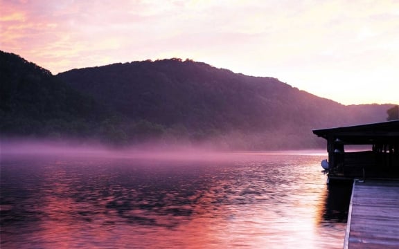 The docks of Lake Austin as the sun rises from behind the mountains