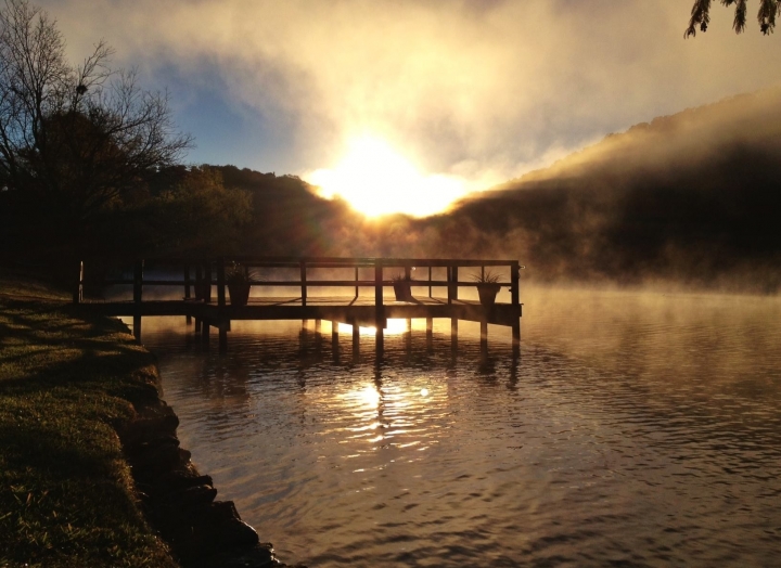 The dock at Lake Austin as the sun sets behind the mountains