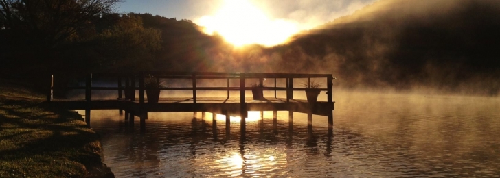The dock at Lake Austin as the sun sets behind the mountains