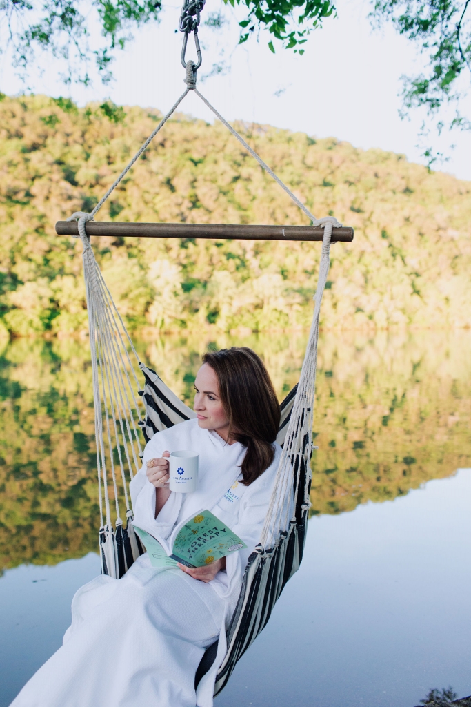 Woman in hammock swing over lake austin