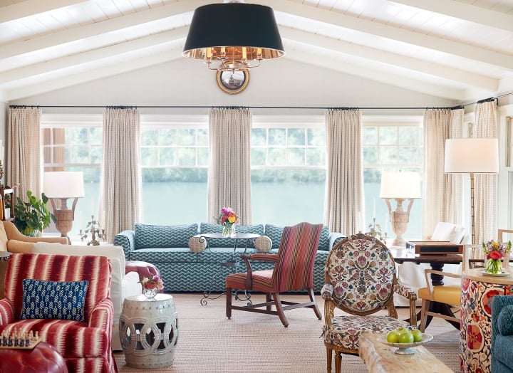 Couches and chairs in front of the floor-to-ceiling and lake-facing living room windows.
