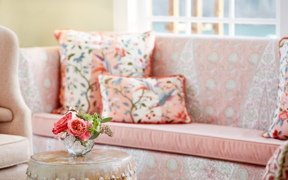 Couch and side table with fresh flowers inside of the library.