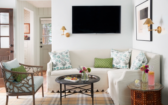 Coffee table, couch, chairs and TV in the Premier Hot Tub Cottage.