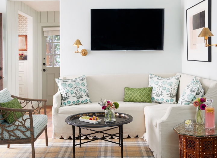 Coffee table, couch, chairs and TV in the Premier Hot Tub Cottage.