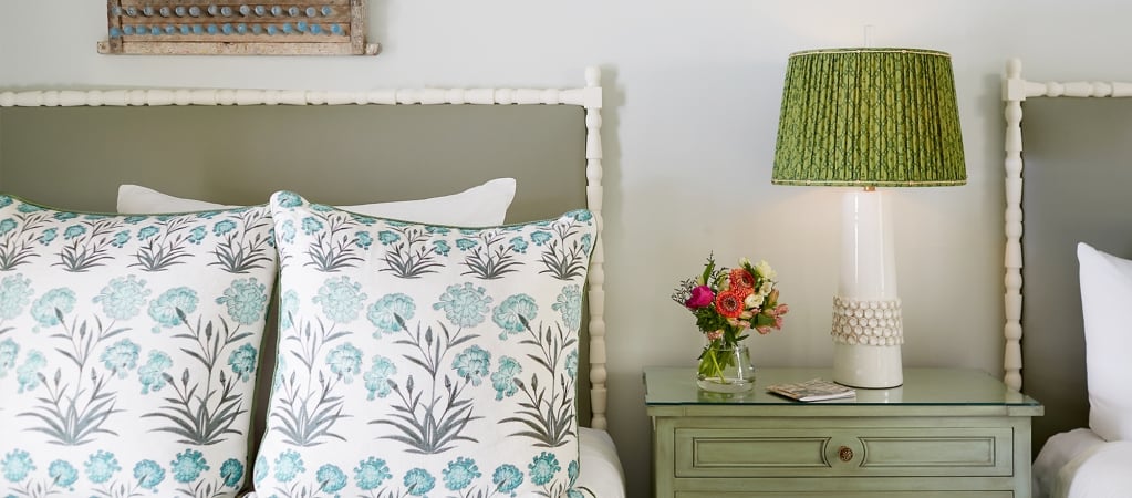 a close-up of a bed with a floral comforter and pillows