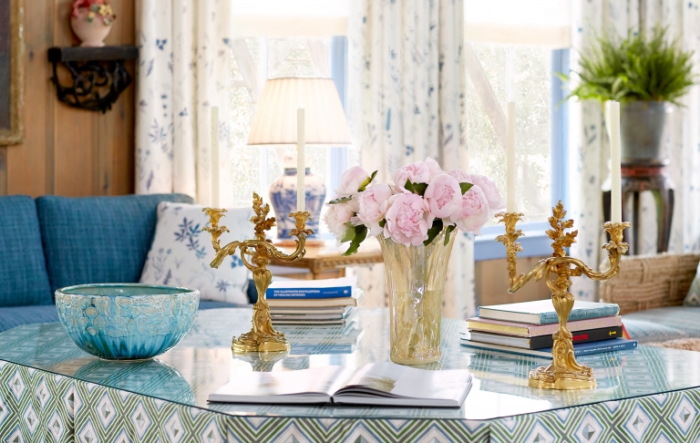 Accent table with fresh flowers and gold candle holders in the Blue Room