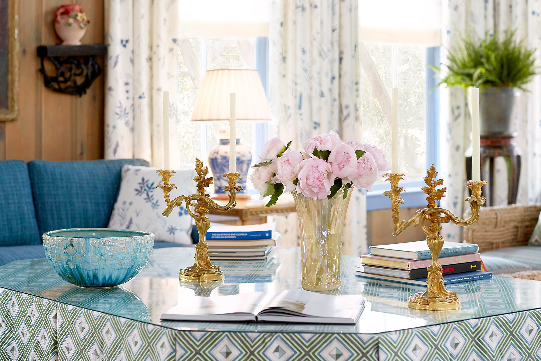 Accent table with fresh flowers and gold candle holders in the Blue Room