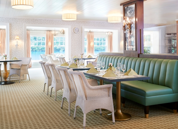 Long green bench and white wicker chairs inside the dining room