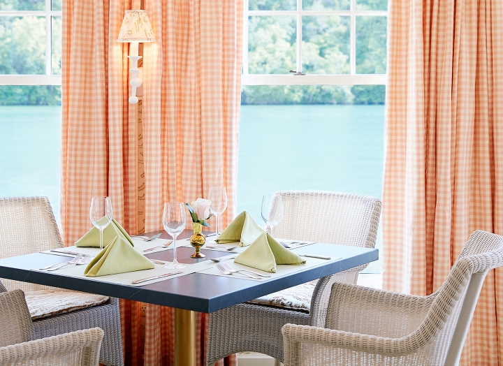 White wicker chairs around a set table in the dining room