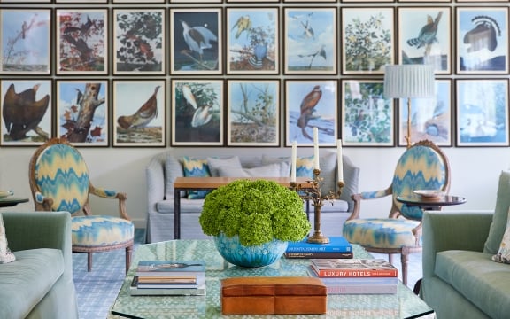 Coffee table and multicolored accent furniture in front of the Treehouse gallery wall