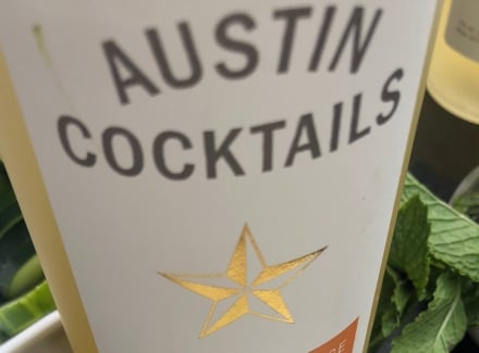 Close-up of Austin Cocktails bottle with mint and lime