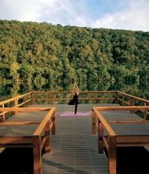 A woman does yoga as the sunrises on a dock over Lake Austin.