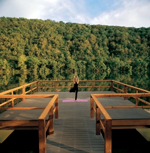 A woman does yoga as the sunrises on a dock over Lake Austin.