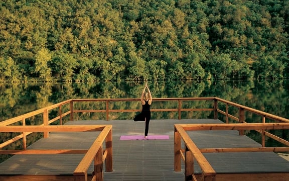 A woman does yoga as the sunrises on a dock over Lake Austin.