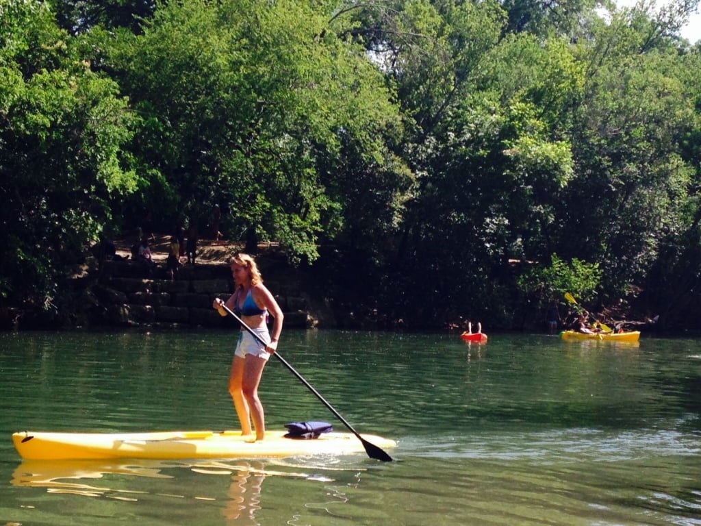 woman on a yellow paddleboard in a lake