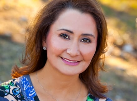 A lady with dark hair smiling at the camera