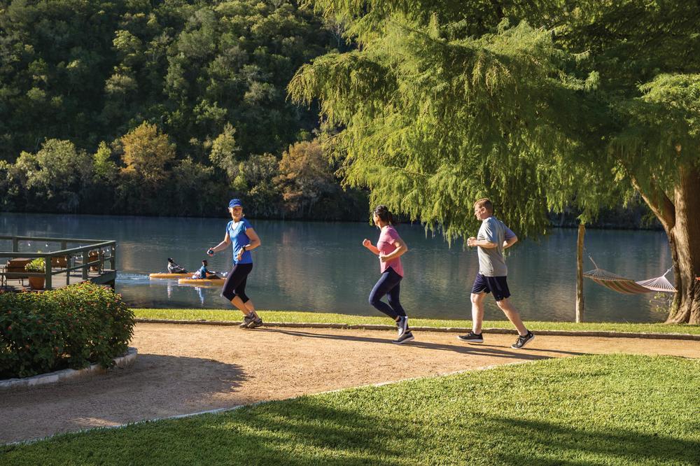 Three people jogging along the lake at Lake Austin Spa Resort