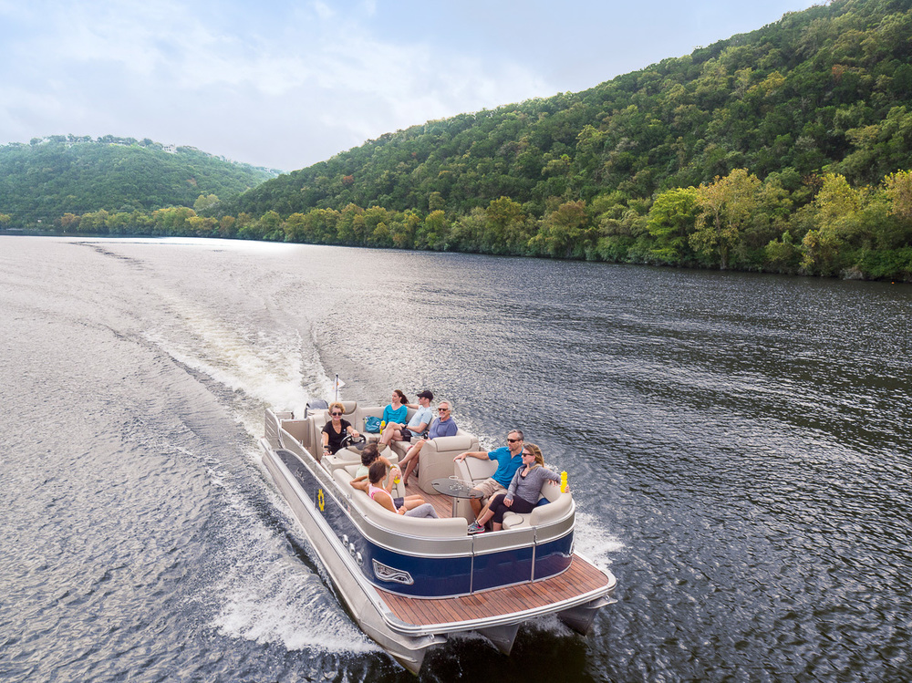 drone shot of pontoon boat cruising on Lake Austin