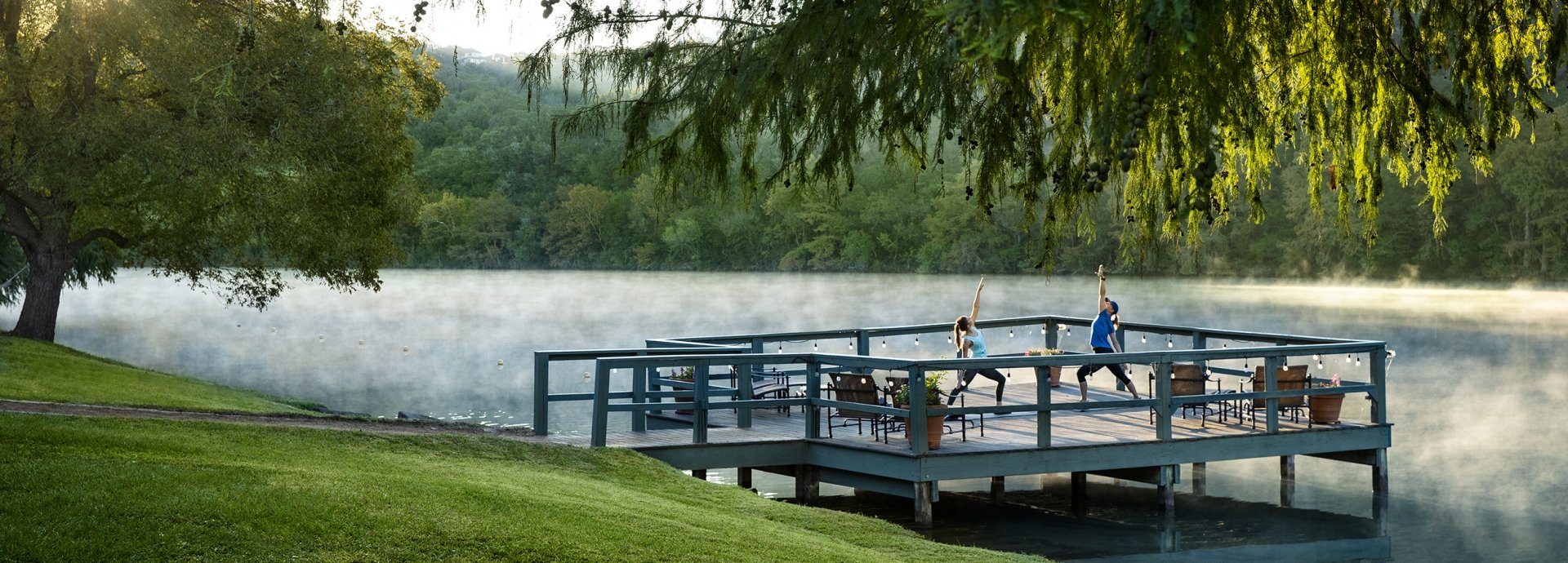 People doing yoga at the lake dock