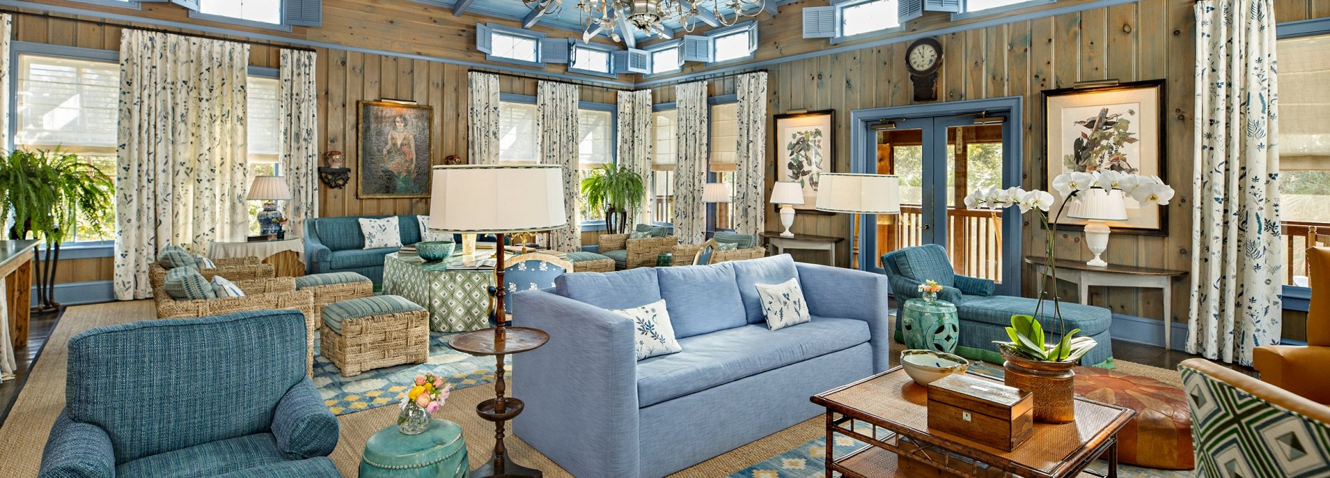 Full view of the Blue room with sets of couches, tables, chairs and beautiful lights