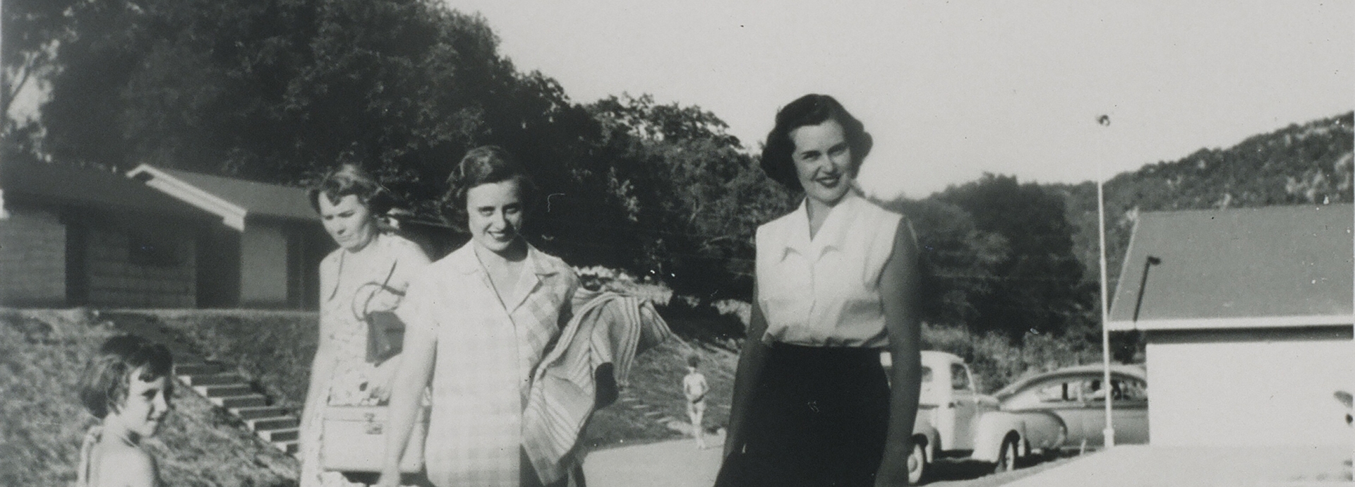 Three women standing by the lake back in time