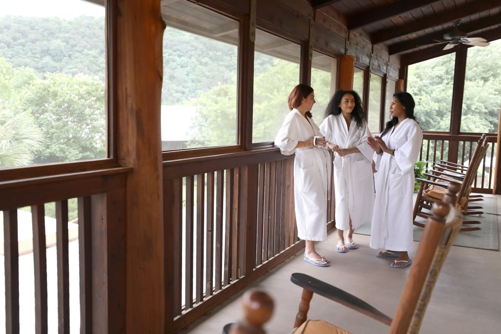 A group of three women in robes chatting outside the Blue Room