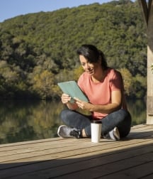 woman reading a tablet on the boat dock at Lake Austin Spa Resort