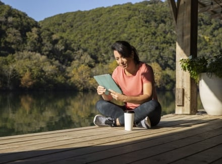 woman reading a tablet on the boat dock at Lake Austin Spa Resort