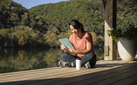 woman reading a tablet on the boat dock at Lake Austin Spa Resort