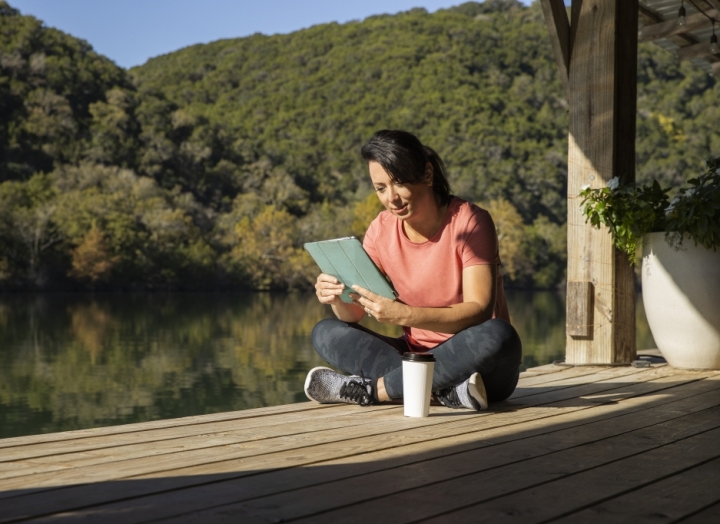woman reading a tablet on the boat dock at Lake Austin Spa Resort