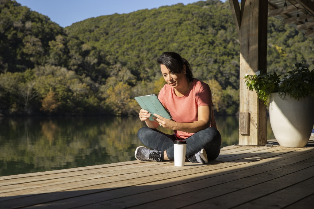 woman reading a tablet on the boat dock at Lake Austin Spa Resort