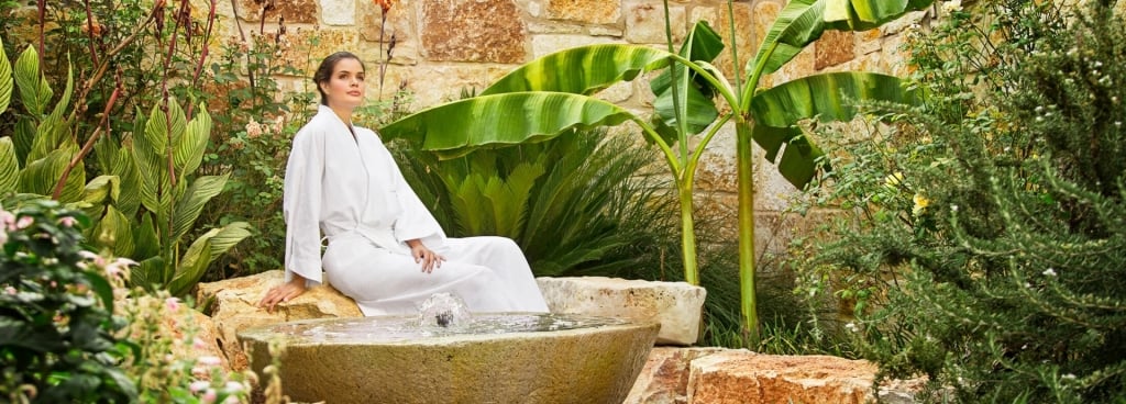 A woman sitting by the tub outside of the spa