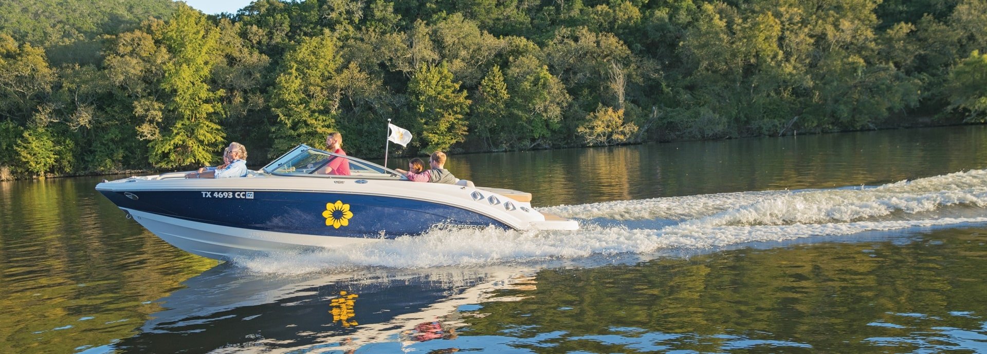 Three people enjoying the view on a boat on the lake