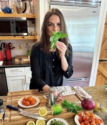Chef Rita standing with ingredients for her dish displayed on the table