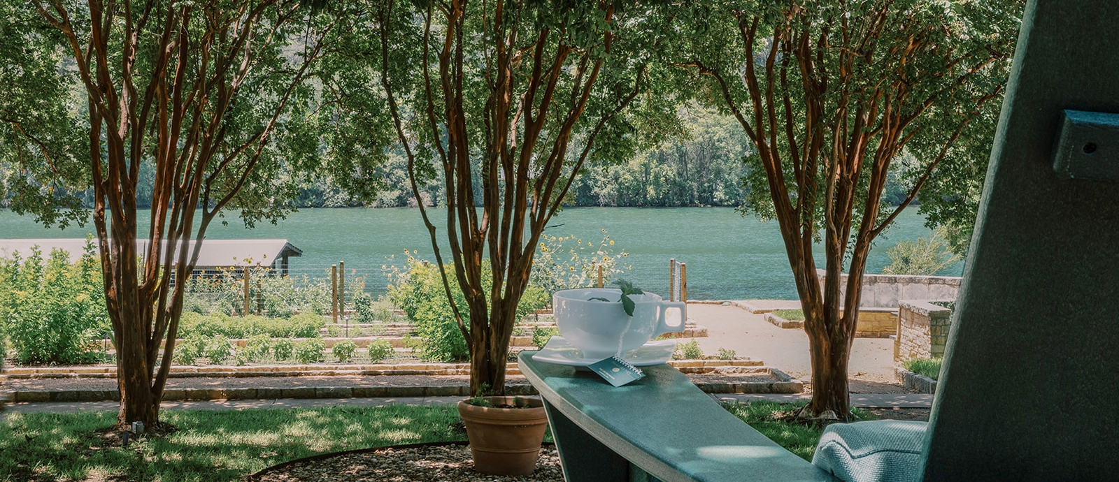 A cup of tea on a chair looking out to the lake