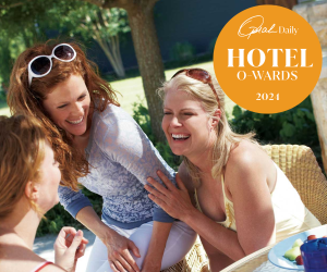 Three female friends chatting and laughing by the pool