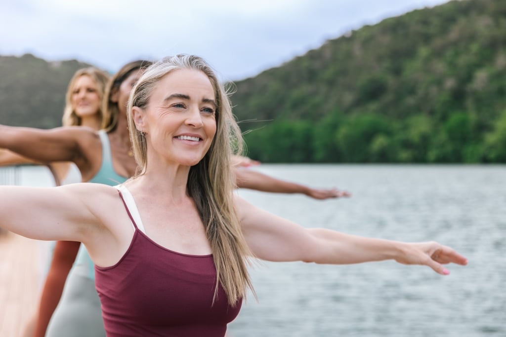 ladies doing yoga by a lake