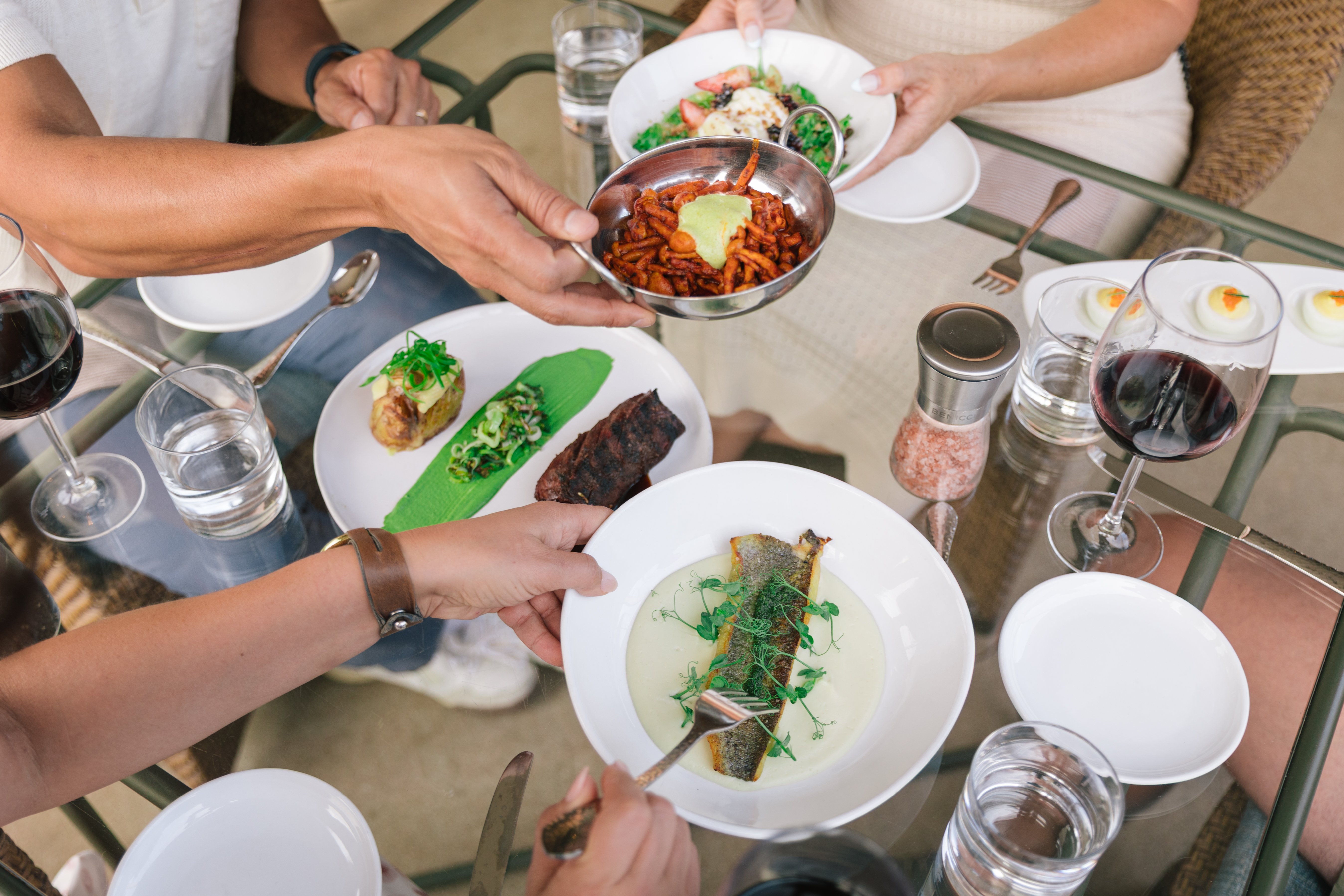 A table set with plates of food and glasses of wine